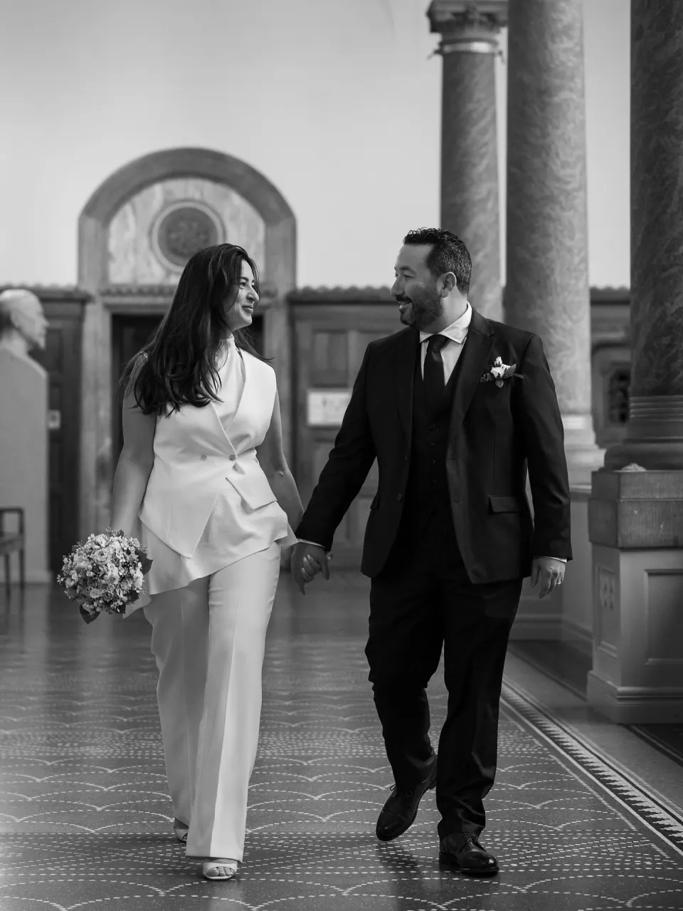 Couple holding hands inside Copenhagen City Hall on their wedding day